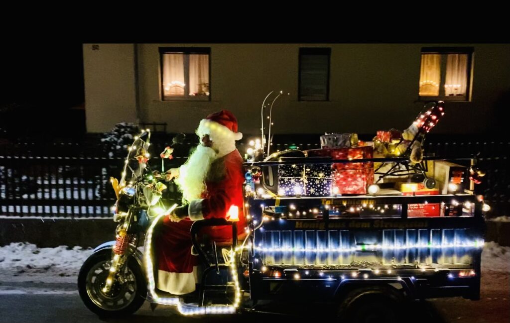Als Weihnachtsmann verkleideter Mann fährt mit seinem geschmückten Cargo Runner E-Lastenrad