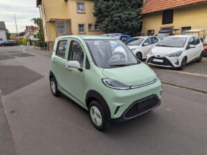 Dreiviertelansicht von vorn links auf das mintgrüne Elektroauto