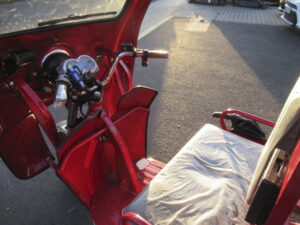 Innenraumaufnahme des roten Cargo Runner Classic Plus mit Blick auf Fahrersitz und Lenker