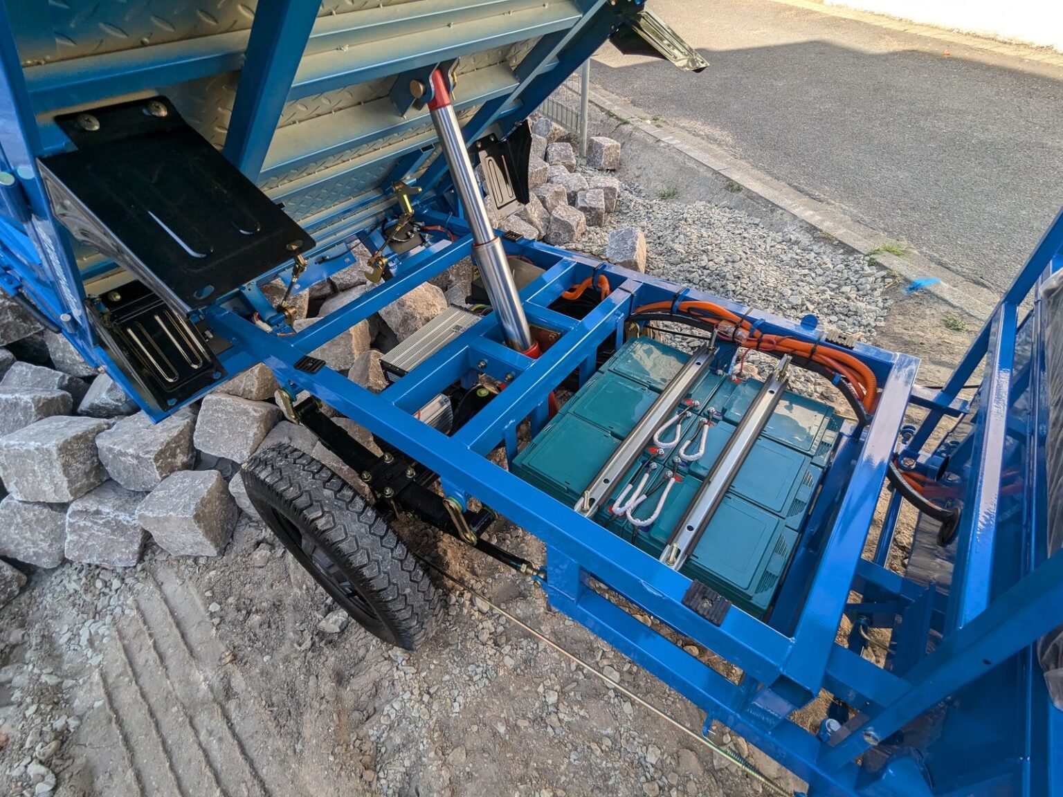 Geöffnete Ladefläche mit Blick auf den Batterieraum des blauen Modells