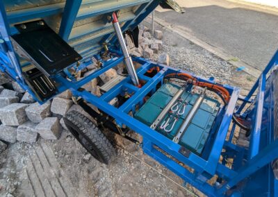 Geöffnete Ladefläche mit Blick auf den Batterieraum des blauen Modells