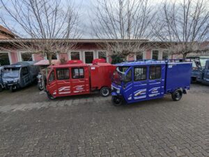 Modellübersicht Doppelkabiner in Rot und Blau, parkend auf einem Innenhof