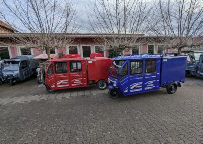 Modellübersicht Doppelkabiner in Rot und Blau, parkend auf einem Innenhof