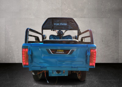 Rückansicht des blauen Compact mit markanten Rückleuchten und Pritschenrahmen