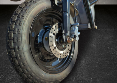Detailaufnahme der Vorderradbremse mit Bremsscheibe und Aufhängung