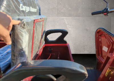 Detailaufnahme der hochgeklappten Sitzbank eines roten Cargo Runner Compact