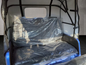 Rückbank im Innenraum des blauen HIGo Modells mit Schutzfolie auf der Sitzfläche