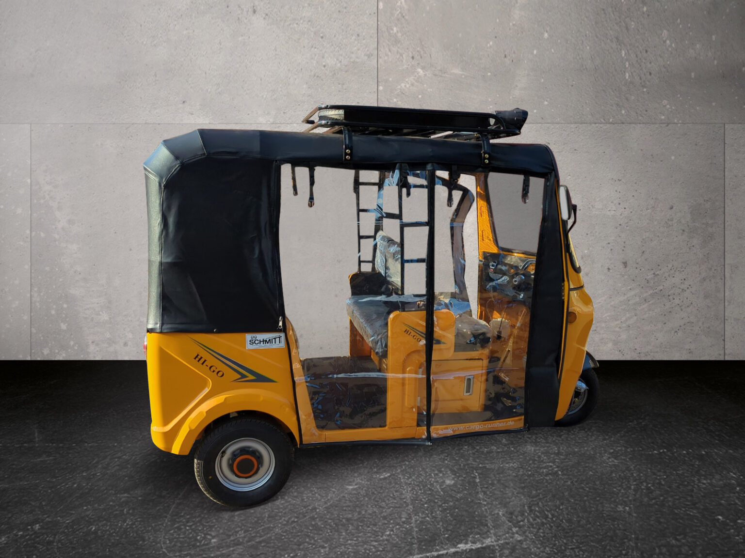 Seitenansicht des gelben HIGo mit offenem Einstieg und Rückbank