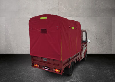 Dreiviertel-Heckansicht links des Cargo Runner Toro mit rotem Planenaufbau