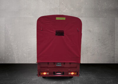 Rückansicht des Cargo Runner Toro mit roter Plane, zentral fotografiert