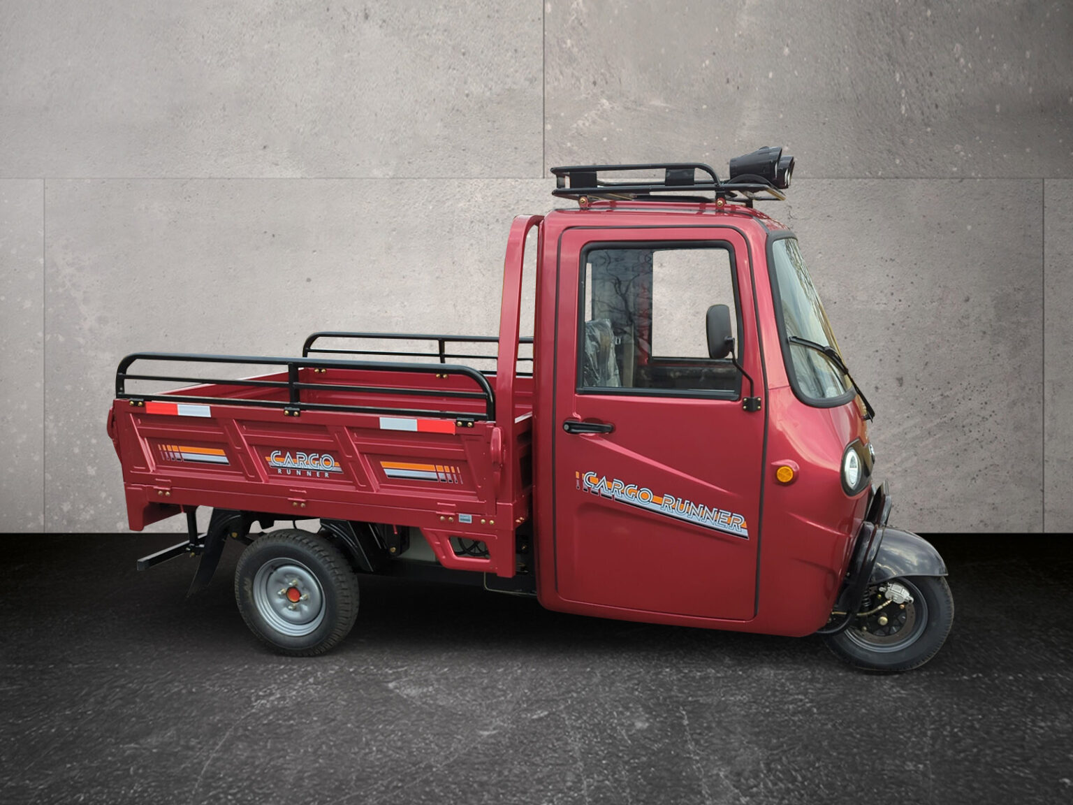 Seitenansicht Voltina in Rot mit gekippter Ladefläche, fotografiert von links