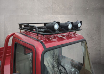 Nahaufnahme des roten Dachträgers mit Fernscheinwerfern des Cargo Runner Voltina